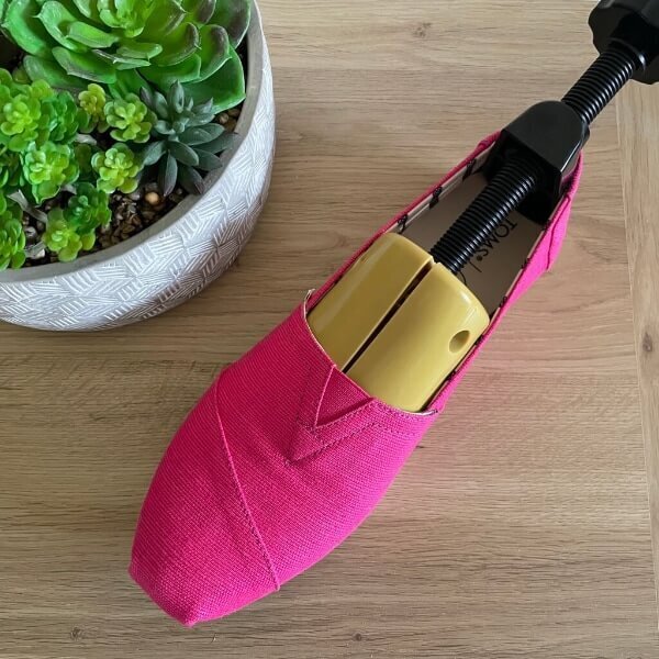 Shoe stretcher inside pink Toms shoe
