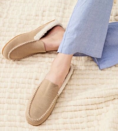 Feet wearing Rothy's scuff sherpa lined slippers available up to size 13 in birch tan shade