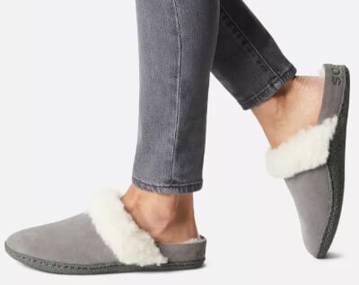 Woman's feet wearing Sorel Nakiska Gray suede faux fur slipper slides up to size 12